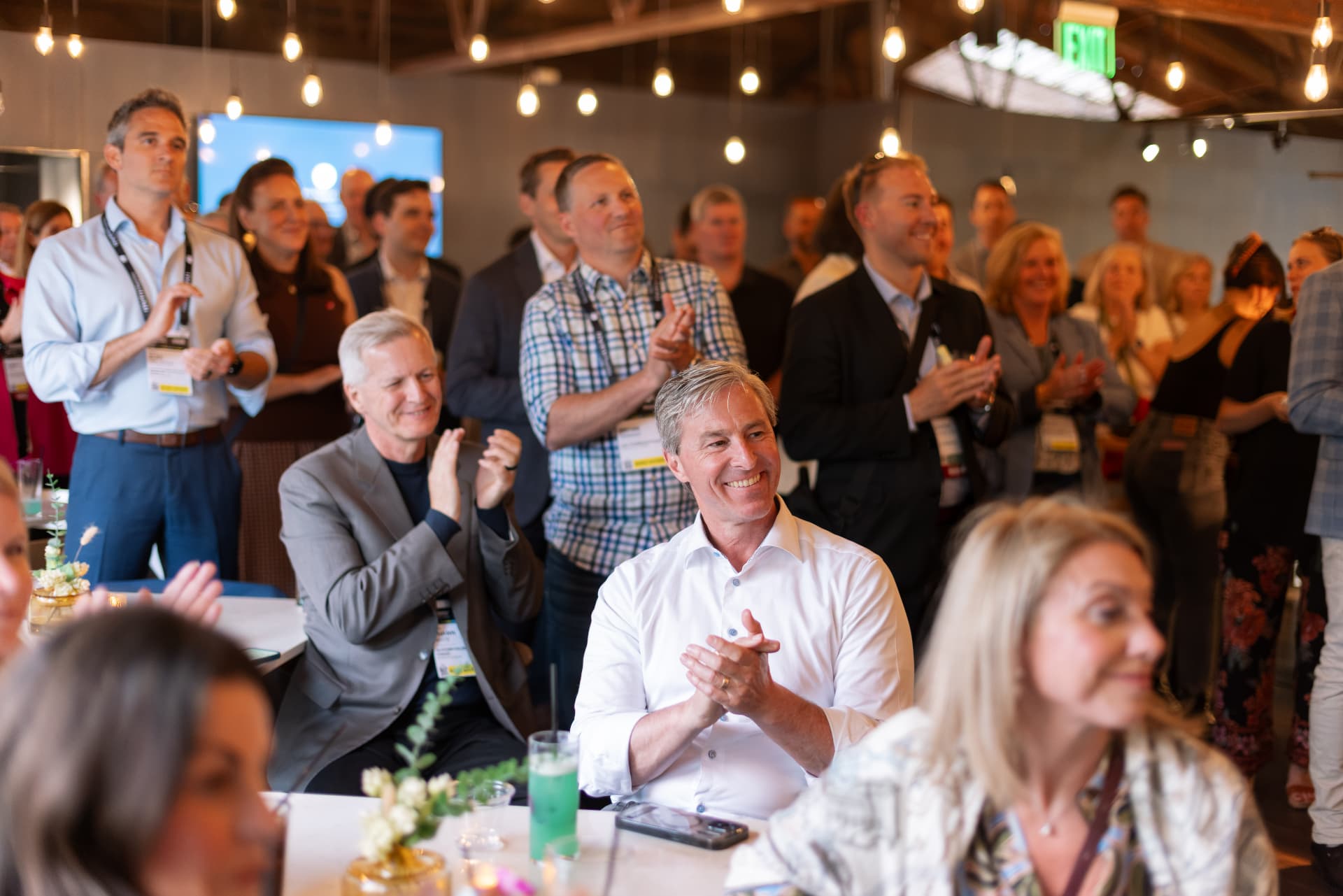 Guests applauding during remarks at the reception